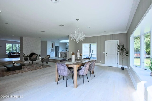 8 Olden Ct, Colts Neck, NJ 07722 - dining area featuring light wood-type flooring, a chandelier, a brick fireplace, and ornamental molding