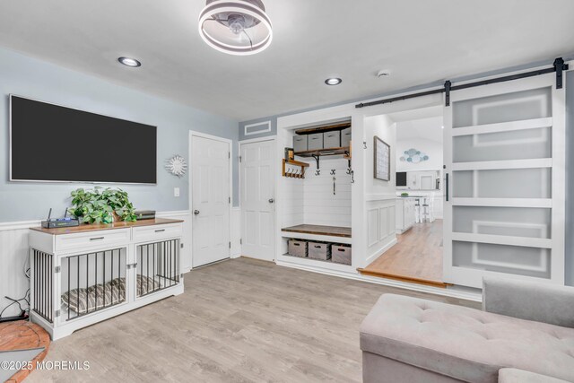 5 Westbrook Cir, Howell, NJ 07731 - living area with a barn door, light wood finished floors, a wainscoted wall, and recessed lighting
