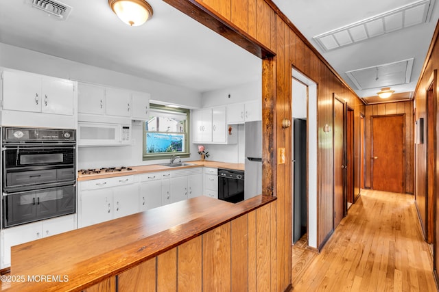 162 Delaware Ave, Atlantic Highlands, NJ 07716 - kitchen featuring black appliances, wood counters, light wood-type flooring, a sink, and white cabinetry