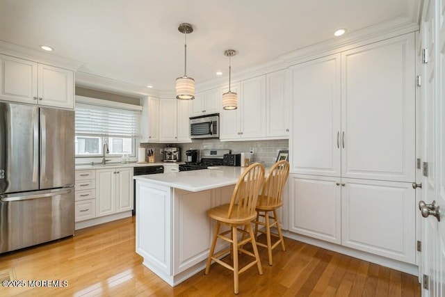 580 Patten Ave # 53, Long Branch, NJ 07740 - kitchen featuring stainless steel appliances, white cabinets, a breakfast bar, light countertops, and recessed lighting