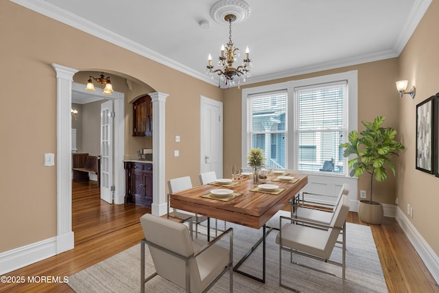 511 4th Ave, Asbury Park, NJ 07712 - dining area featuring ornate columns, a chandelier, light wood-type flooring, arched walkways, and ornamental molding