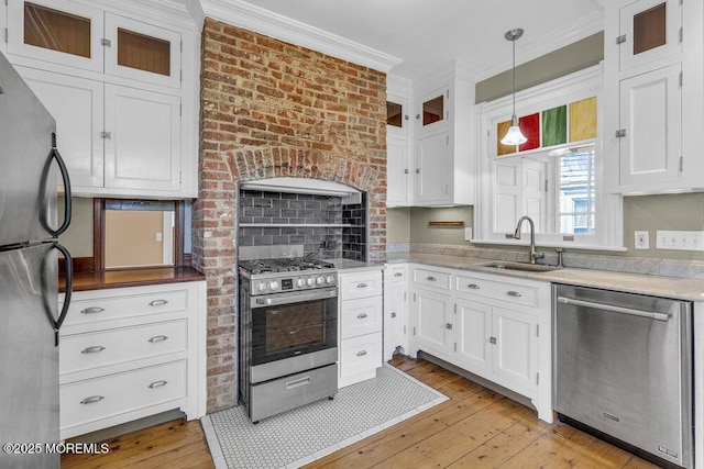 511 4th Ave, Asbury Park, NJ 07712 - kitchen with stainless steel appliances, white cabinets, light wood-style floors, a sink, and crown molding