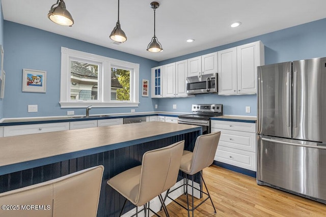 511 4th Ave, Asbury Park, NJ 07712 - kitchen with appliances with stainless steel finishes, a sink, a breakfast bar, white cabinetry, and recessed lighting