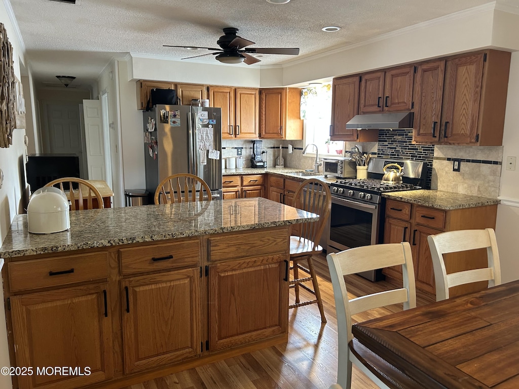 19 Elm St, Beachwood, NJ 08722 - kitchen with stainless steel appliances, under cabinet range hood, a sink, a ceiling fan, and brown cabinetry