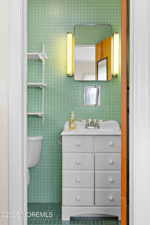 24 Heidl Ave, West Long Branch, NJ 07764 - bathroom featuring vanity, toilet, tile patterned floors, and tile walls
