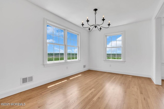 27 Main St, Port Monmouth, NJ 07758 - spare room featuring a chandelier, plenty of natural light, light wood finished floors, and baseboards
