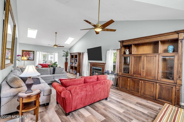 1771 Calico Ln, Toms River, NJ 08753 - living area with ceiling fan, a skylight, a glass covered fireplace, high vaulted ceiling, and light wood-style floors