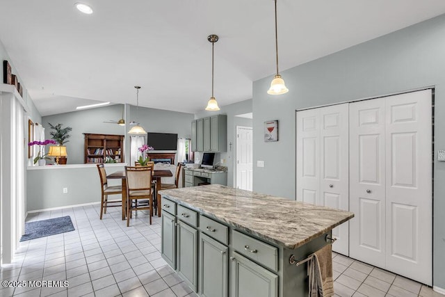 1771 Calico Ln, Toms River, NJ 08753 - kitchen with light tile patterned floors, vaulted ceiling, a center island, pendant lighting, and light stone counters
