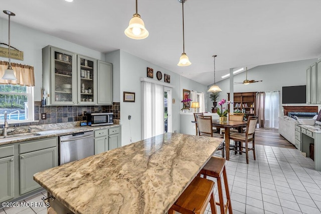 1771 Calico Ln, Toms River, NJ 08753 - kitchen featuring appliances with stainless steel finishes, vaulted ceiling, a sink, light tile patterned floors, and decorative backsplash