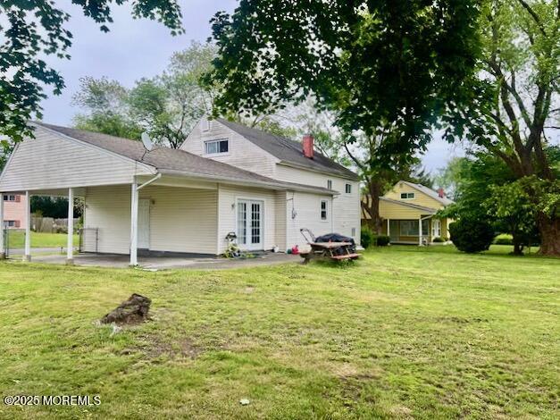 706 Tide Pl, Neptune Township, NJ 07753 - back of property featuring a lawn, a patio, and a chimney