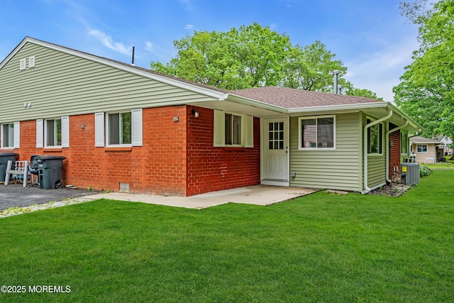 10D Heron St, Manchester, NJ 08759 - back of house featuring central AC unit, a lawn, a shingled roof, a patio area, and brick siding