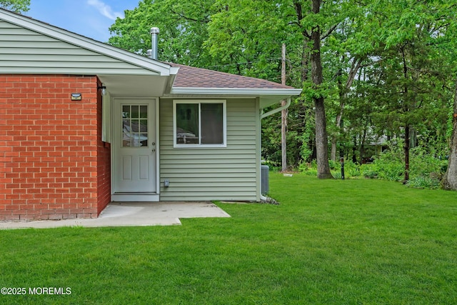 10D Heron St, Manchester, NJ 08759 - view of exterior entry featuring a yard, roof with shingles, and brick siding