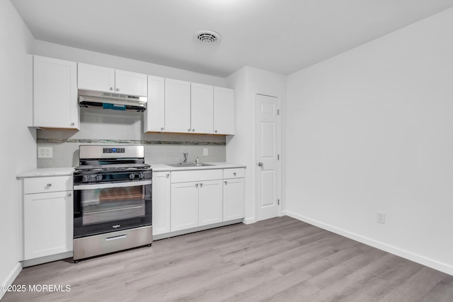 10D Heron St, Manchester, NJ 08759 - kitchen featuring stainless steel range with gas stovetop, under cabinet range hood, light countertops, baseboards, and white cabinets