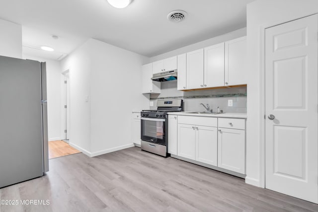 10D Heron St, Manchester, NJ 08759 - kitchen featuring appliances with stainless steel finishes, under cabinet range hood, a sink, light countertops, and light wood finished floors