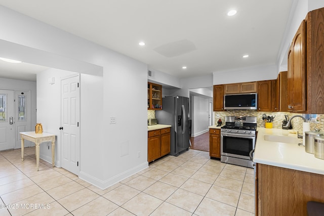39 Sarah Ln, Howell, NJ 07731 - kitchen with stainless steel appliances, a sink, light tile patterned floors, light countertops, and decorative backsplash