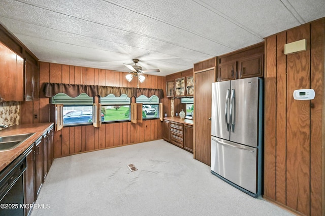 119 Village Rd, Morganville, NJ 07751 - kitchen with freestanding refrigerator, wooden walls, dishwasher, a ceiling fan, and a sink