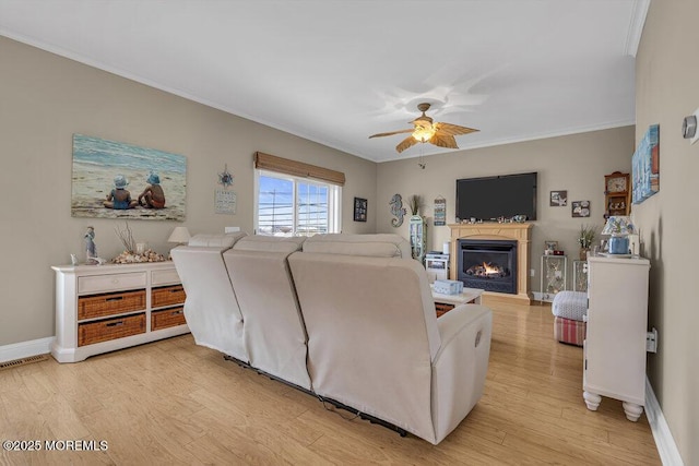 200 San Fernando Dr, Lavallette, NJ 08735 - living area with a ceiling fan, light wood-style floors, crown molding, a lit fireplace, and baseboards