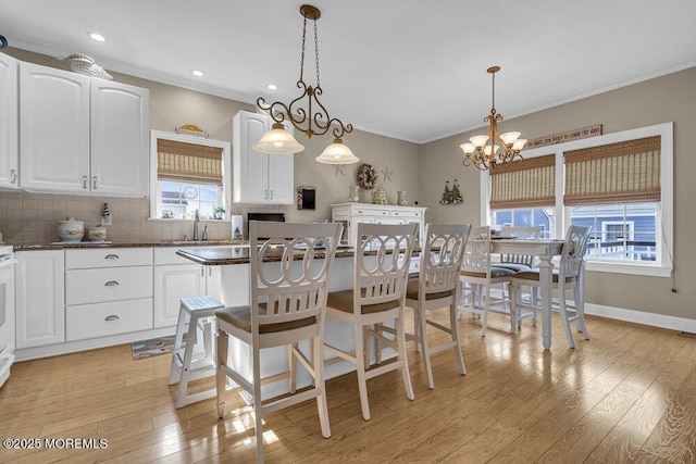 200 San Fernando Dr, Lavallette, NJ 08735 - kitchen with ornamental molding, backsplash, a chandelier, white cabinets, and light wood-style floors