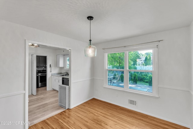 824 Broadway Blvd, Toms River, NJ 08757 - unfurnished dining area featuring a sink, light wood-style flooring, and baseboards