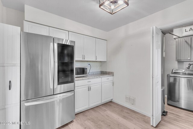 824 Broadway Blvd, Toms River, NJ 08757 - kitchen with stainless steel appliances, washer / clothes dryer, light wood-style flooring, and white cabinetry