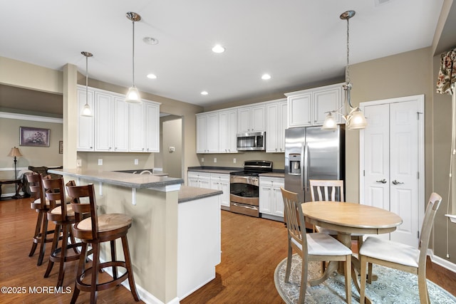 12 Stemson Ct, Little Egg Harbor, NJ 08087 - kitchen with appliances with stainless steel finishes, a peninsula, wood finished floors, decorative light fixtures, and recessed lighting