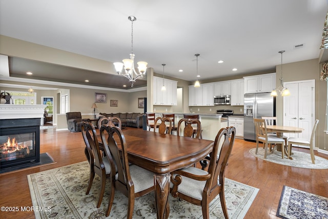 12 Stemson Ct, Little Egg Harbor, NJ 08087 - dining area featuring a multi sided fireplace, light wood finished floors, recessed lighting, a chandelier, and baseboards
