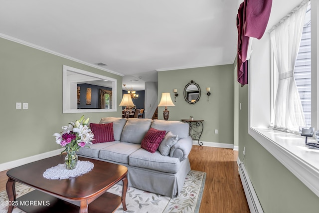 2 Miriam Dr, Matawan, NJ 07747 - living room with a chandelier, wood finished floors, baseboards, a baseboard radiator, and ornamental molding