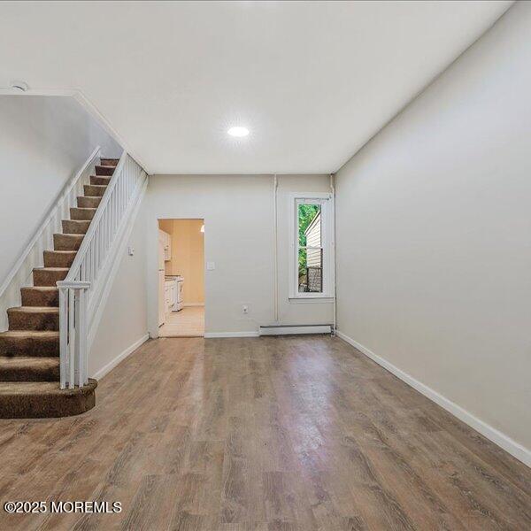 1262 Thurman St, Camden, NJ 08104 - unfurnished living room featuring a baseboard radiator, wood finished floors, baseboards, stairway, and recessed lighting