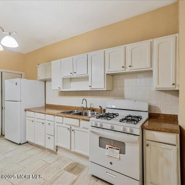 1262 Thurman St, Camden, NJ 08104 - kitchen featuring white appliances, a sink, tasteful backsplash, and white cabinets