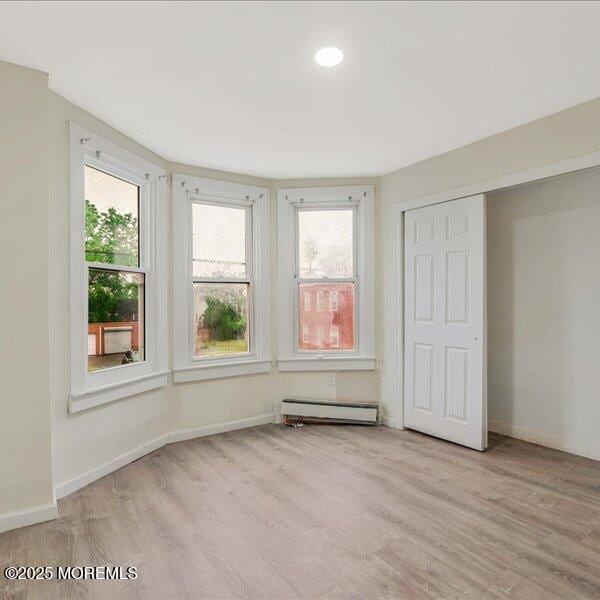 1262 Thurman St, Camden, NJ 08104 - unfurnished bedroom with wood finished floors, baseboard heating, and multiple windows