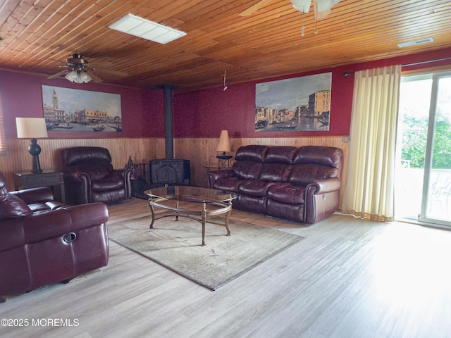 113 Boulder Lake Dr, Little Egg Harbor, NJ 08087 - living room with a ceiling fan, a wood stove, wood walls, wood finished floors, and wooden ceiling