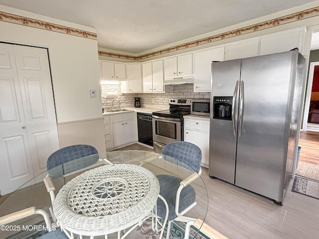 113 Boulder Lake Dr, Little Egg Harbor, NJ 08087 - kitchen with stainless steel appliances, under cabinet range hood, white cabinets, wainscoting, and light countertops