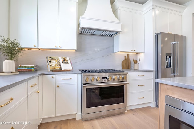 205 Parkway Pt, Pleasant Beach, NJ 08742 - kitchen with premium range hood, premium appliances, light wood-type flooring, and white cabinetry