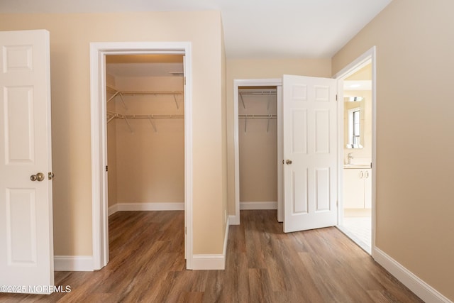 2708 Ridgefield Ct Unit 2708, Helmetta, NJ 08828 - unfurnished bedroom featuring wood finished floors, baseboards, and multiple closets