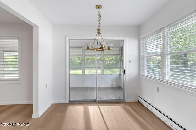 8 Holmes Ct, Brick, NJ 08724 - unfurnished dining area with a baseboard radiator, a chandelier, and light wood-type flooring