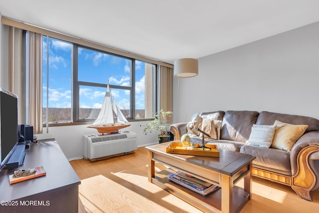 1 Scenic Dr Unit 511, Highlands, NJ 07732 - living area with light wood-style floors, healthy amount of natural light, a wall unit AC, and baseboards