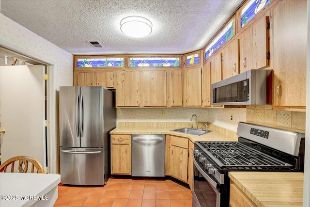 5-3 Portland Ct, Freehold, NJ 07728 - kitchen with appliances with stainless steel finishes, a sink, light countertops, light tile patterned floors, and a textured ceiling