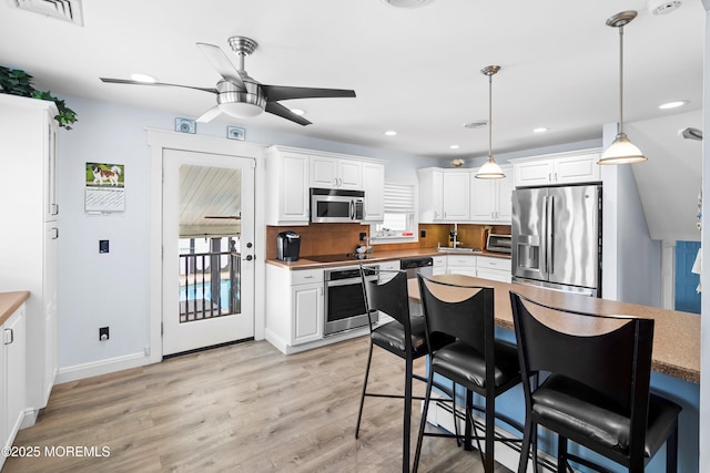 660 Summit Ave, Kenilworth, NJ 07033 - kitchen with stainless steel appliances, ceiling fan, white cabinetry, a sink, and light wood-style flooring
