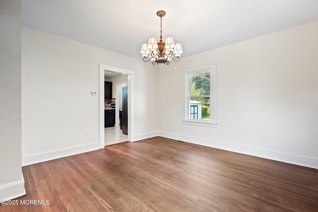 23 Stokes St, Freehold, NJ 07728 - empty room featuring a chandelier, wood finished floors, and baseboards