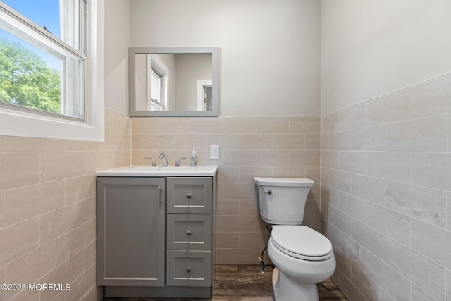 23 Stokes St, Freehold, NJ 07728 - half bathroom featuring tile walls, toilet, vanity, wood finished floors, and a wainscoted wall