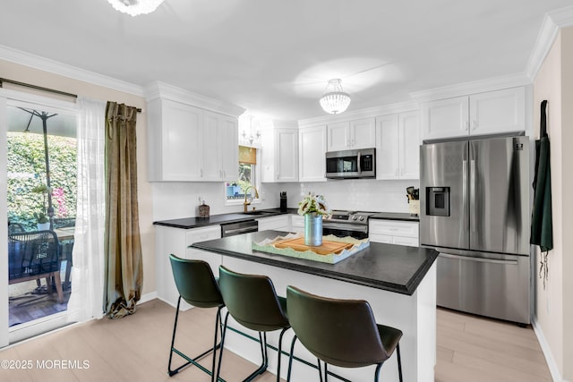 1 Portland Rd Unit 13, Highlands, NJ 07732 - kitchen featuring appliances with stainless steel finishes, white cabinetry, backsplash, dark countertops, and light wood-style floors