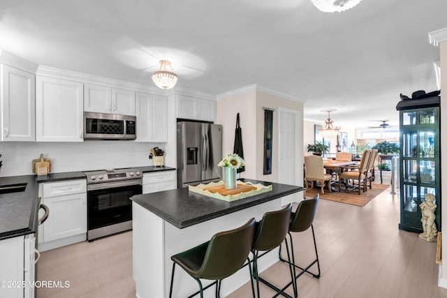 1 Portland Rd Unit 13, Highlands, NJ 07732 - kitchen with stainless steel appliances, white cabinetry, tasteful backsplash, dark countertops, and ornamental molding