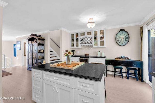 1 Portland Rd Unit 13, Highlands, NJ 07732 - kitchen featuring crown molding, dark countertops, beverage cooler, white cabinets, and light wood-style floors