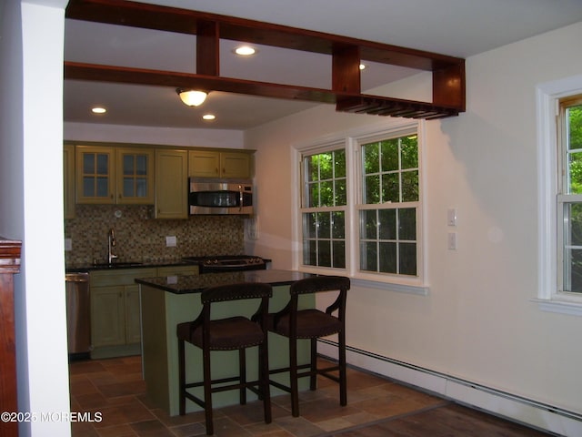 364 Westwood Ave Unit 12, Long Branch, NJ 07740 - kitchen featuring stainless steel appliances, a baseboard radiator, a sink, tasteful backsplash, and dark countertops