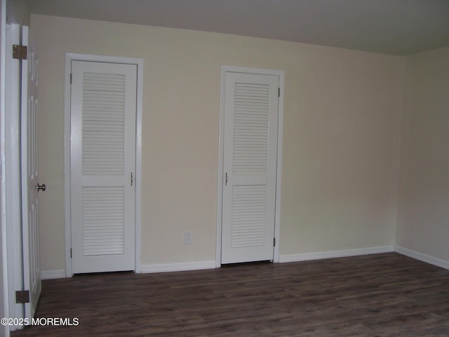 364 Westwood Ave Unit 12, Long Branch, NJ 07740 - unfurnished bedroom featuring dark wood-type flooring, baseboards, and multiple closets