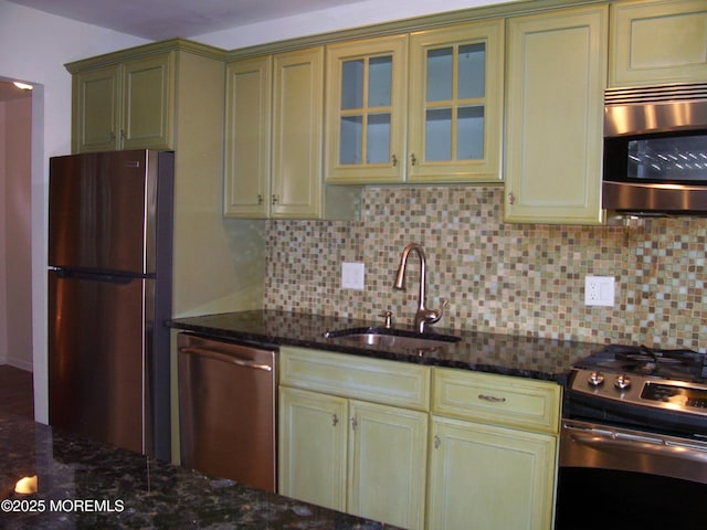 364 Westwood Ave Unit 12, Long Branch, NJ 07740 - kitchen featuring appliances with stainless steel finishes, a sink, backsplash, and dark stone countertops
