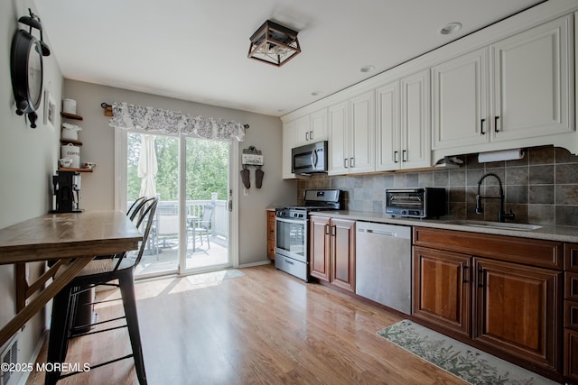 20 Koosman Dr, Leonardo, NJ 07737 - kitchen with appliances with stainless steel finishes, a sink, light wood-style floors, and decorative backsplash