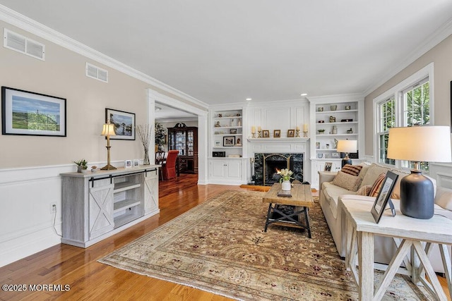 71 Maple Ave, Little Silver, NJ 07739 - living room with light wood-style floors, built in shelves, a high end fireplace, ornamental molding, and a wainscoted wall