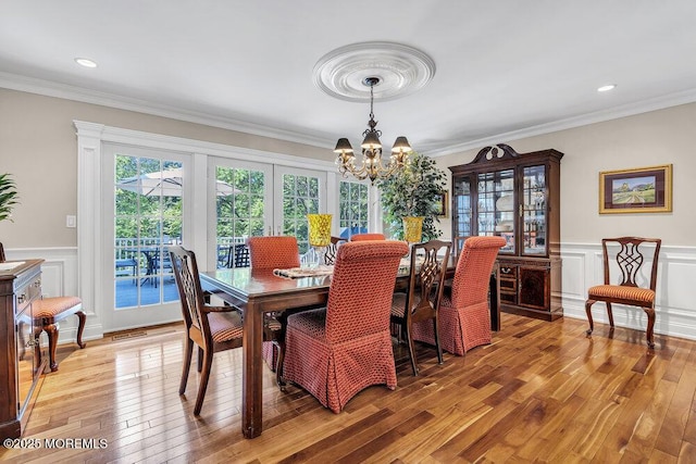 71 Maple Ave, Little Silver, NJ 07739 - dining area featuring a chandelier, light wood-style floors, ornamental molding, a wainscoted wall, and a decorative wall