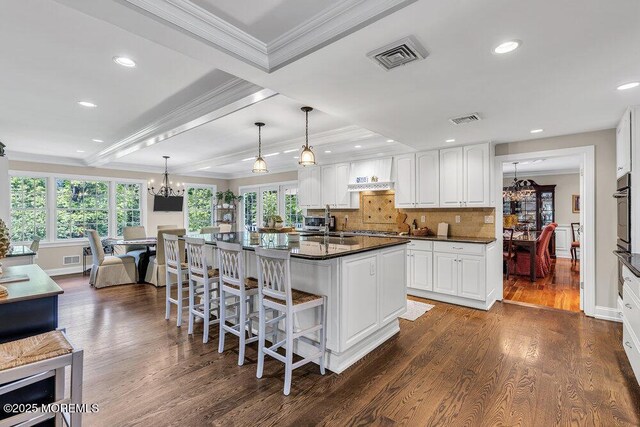 71 Maple Ave, Little Silver, NJ 07739 - kitchen featuring a chandelier, dark countertops, a breakfast bar, dark wood-style floors, and ornamental molding